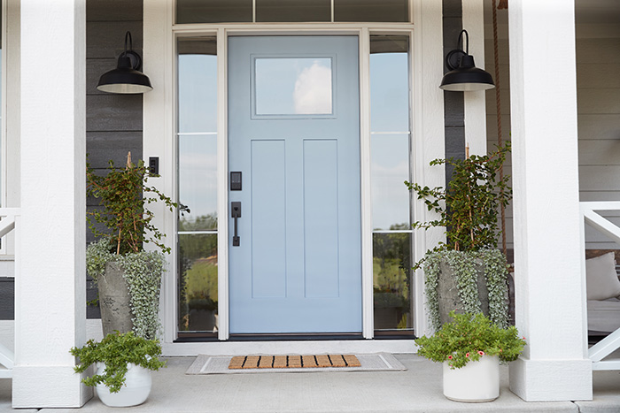 Stylish porch with light blue craftsman front door.