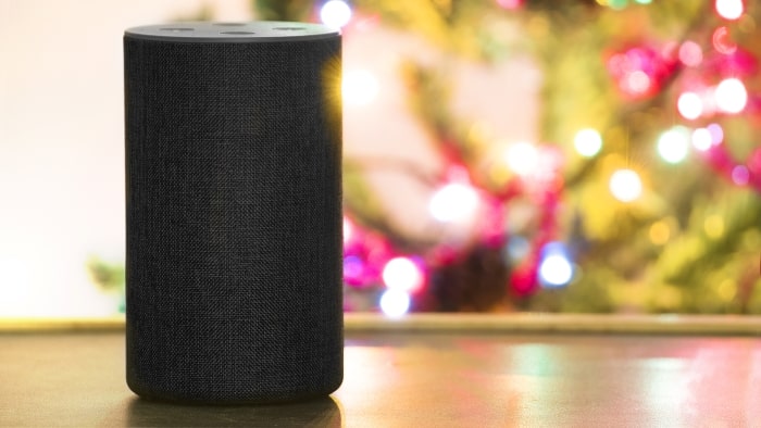 Amazon Echo speaker with a Christmas tree in the background.