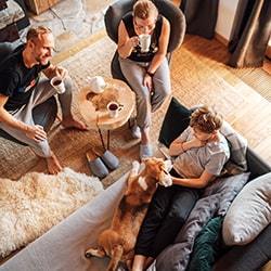 family-talking-in-living-room-with-coffee-and-dog-min