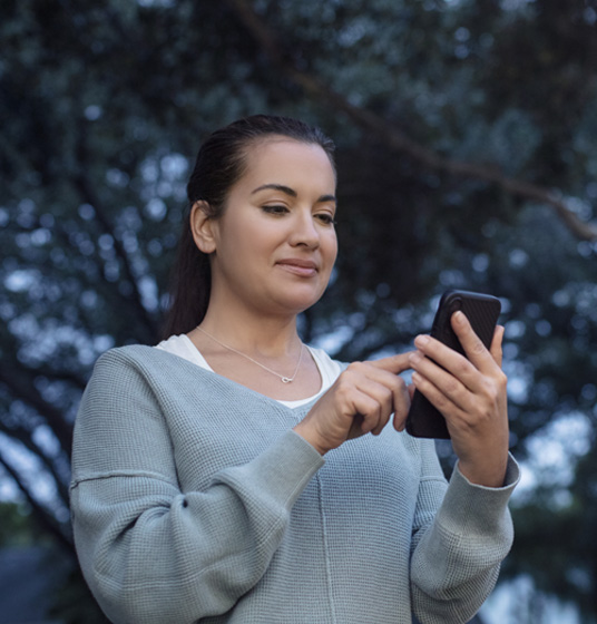 woman using her iPhone to check that her smart lock is locked